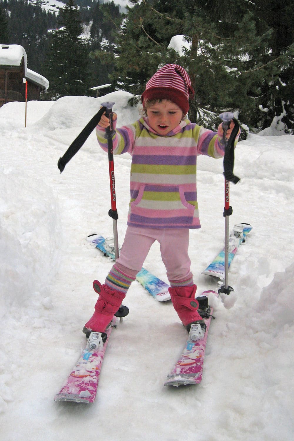 A young child tries to make skis work