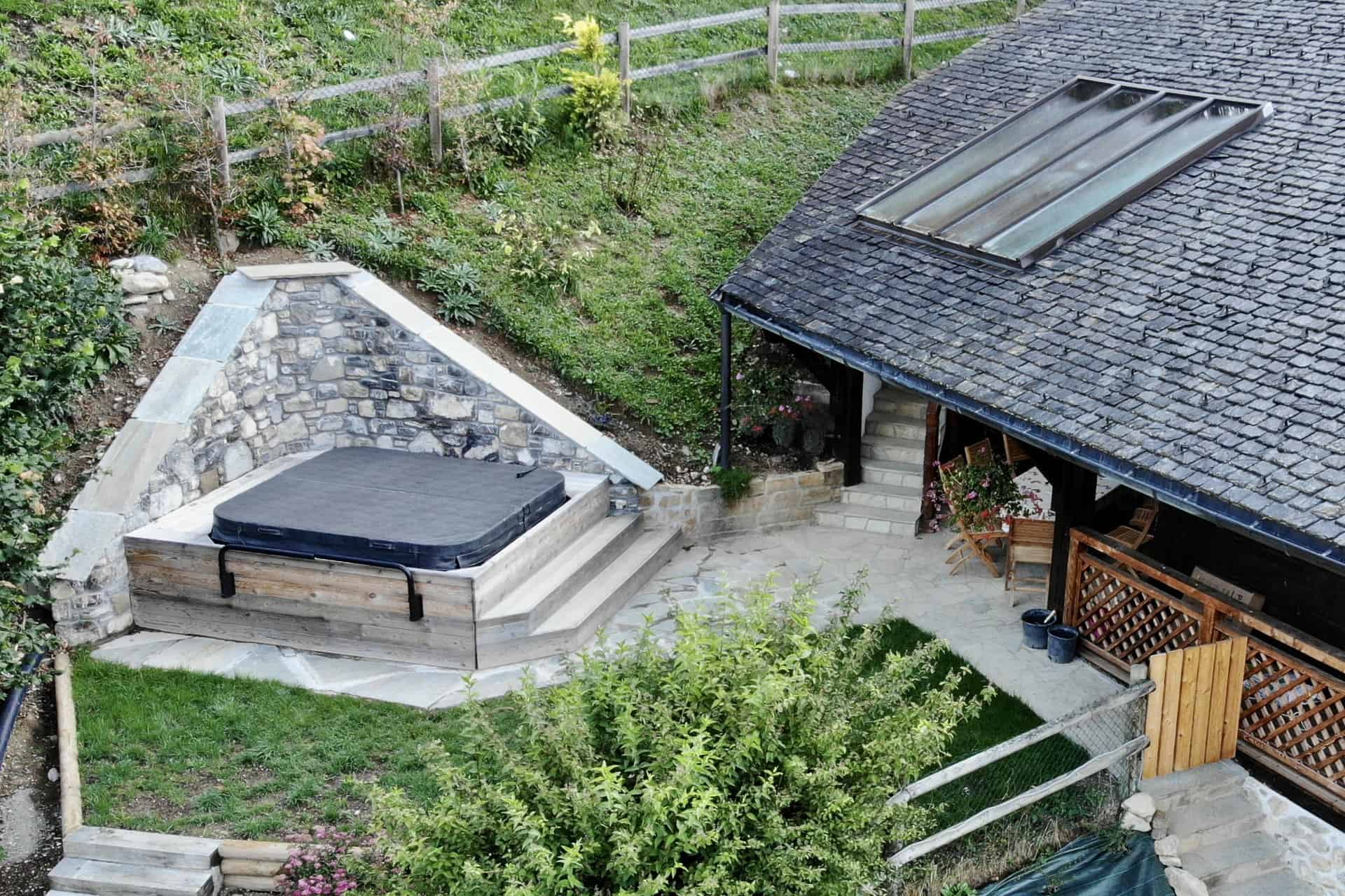 an aerial view of the clarian chalets hot tub beside the chalet in summer