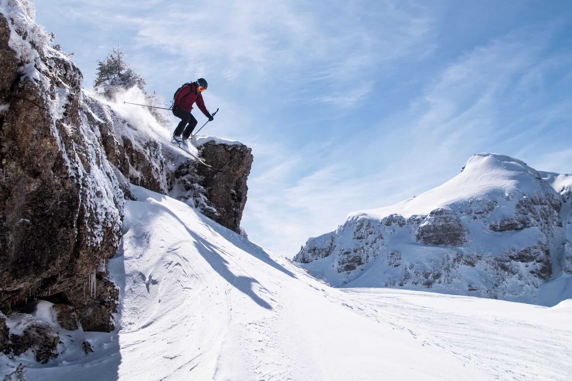 A skier jumping off a small cliff