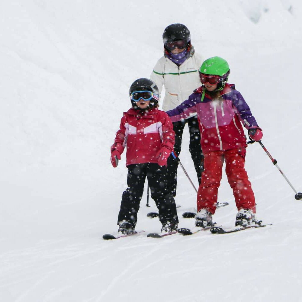 Mum and young children skiing