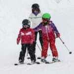 Mum and young children skiing